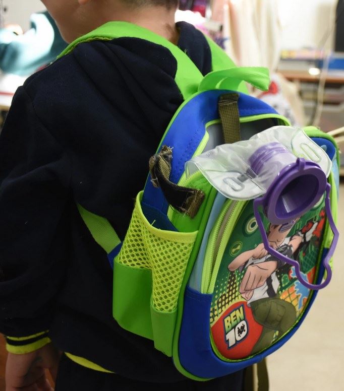 A Feeding Pump backpack for a walking child with the equipment needed for feeding